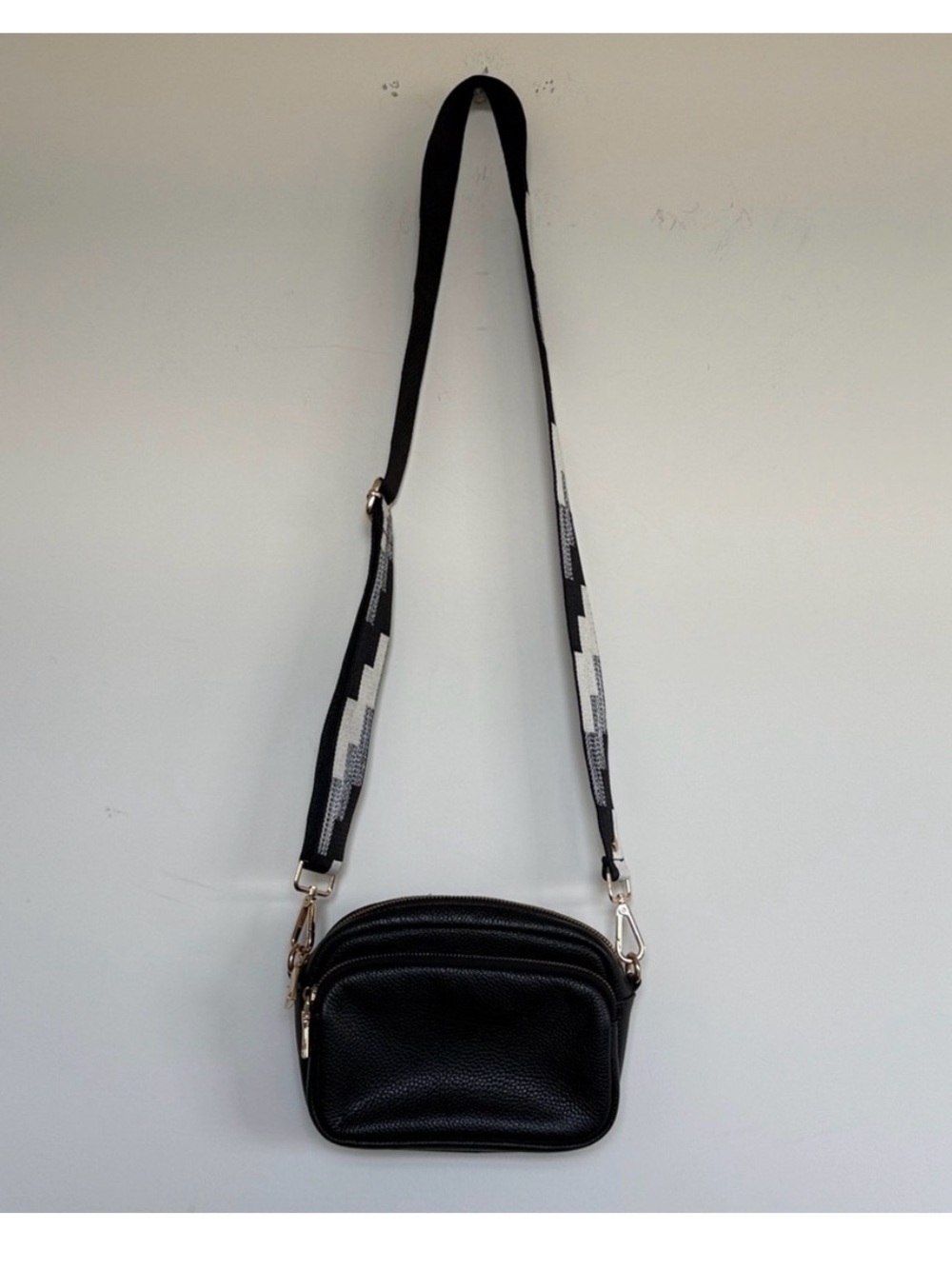 Compact Black Pebble Crossbody with Patterned Strap